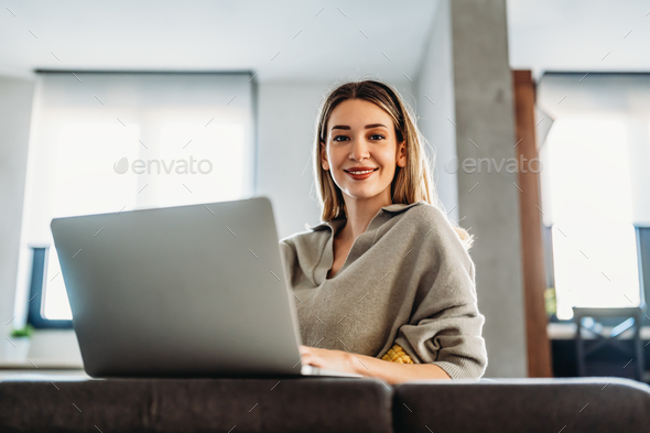 Home office. One smiling woman using laptop. Work, freelance, social media, technology concept. - Stock Photo - Images