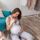 Pregnant woman holding a clock, counting time untill labour - PhotoDune Item for Sale