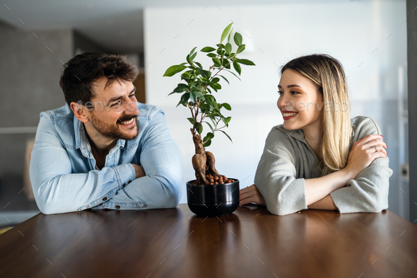 Loving everything about her. Smiling environmentally friendly couple with houseplant - Stock Photo - Images