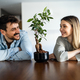 Loving everything about her. Smiling environmentally friendly couple with houseplant - PhotoDune Item for Sale