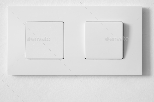 White light switch over a white textured wall. Household