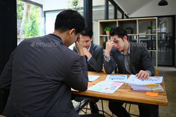 Exhausted business colleagues feel stressed with bad work result or paperwork statistics problem. - Stock Photo - Images