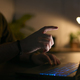 Close Up Of Man Using Laptop At Home At Night With Finger Reaching Out To Touch Screen - PhotoDune Item for Sale