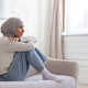 Young woman upset in depression sitting on sofa at home, muslim woman in hijab close up in living - PhotoDune Item for Sale