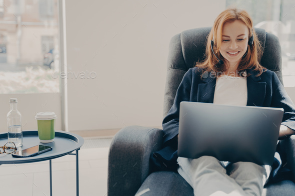 Happy smiling female freelancer during online conference via modern laptop at home
