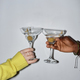 Closeup of two young people holding glasses and toasting with martini - PhotoDune Item for Sale