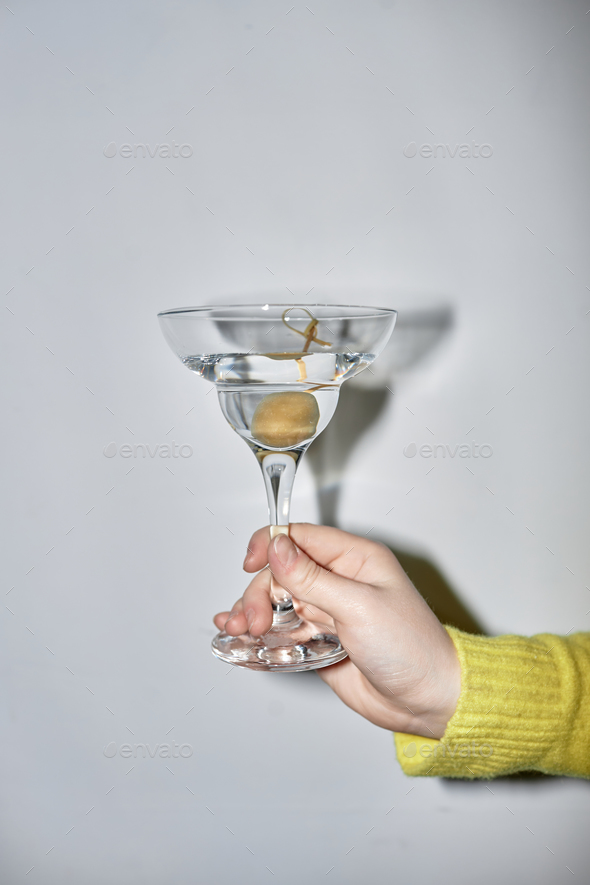 Woman holding martini glass during party with flash - Stock Photo - Images