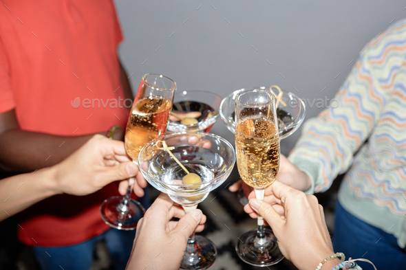 Young people holding glasses and drinking martini - Stock Photo - Images