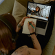 Female student listening to online lecture in headphones and making notes while studying from home - PhotoDune Item for Sale