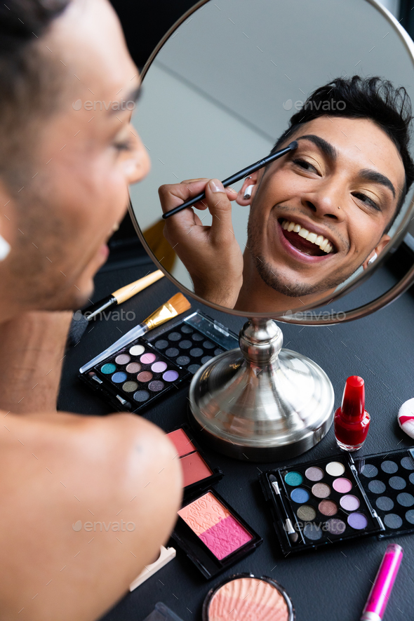 Biracial Transgender Man Looking In Mirror And Putting On Make Up Applying Eyeshadow Stock 6614