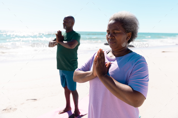 African american senior woman smiling and meditating in prayer