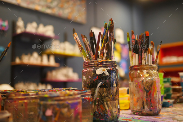 Paints and paint brushes in an artists studio. - Stock Photo - Images