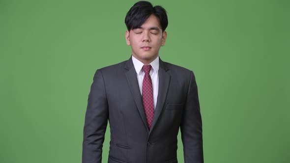 Young Handsome Asian Businessman Relaxing with Eyes Closed alt