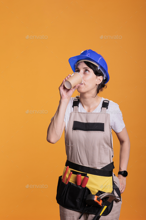 Construction worker serving coffee cup after renovation - Stock Photo - Images