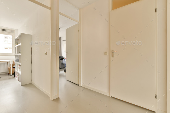 a view of a room with white walls and doors