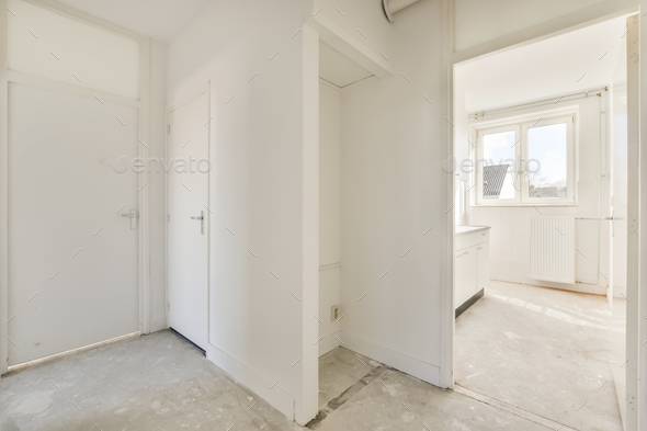 a room with white walls and doors and a window