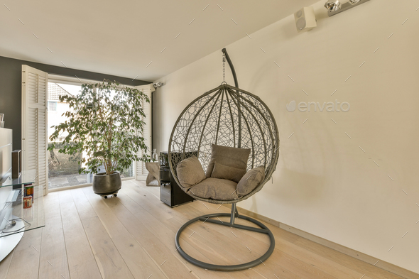 a egg chair in a living room with a tree