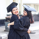 Two women students hugging on graduation day. - PhotoDune Item for Sale