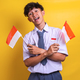 Indonesian high school student man waving flags of Indonesia, celebrating the independence day. - PhotoDune Item for Sale