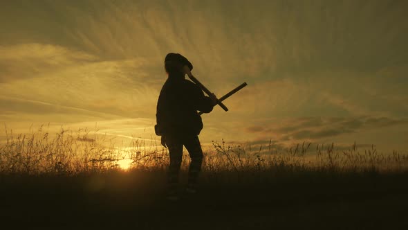 Cute Child Playing with Toy Wooden Airplane in the Field at Sunset Time. Silhouette of Kid Playing alt