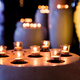 Flame of many candles burning on blurred lights background. - PhotoDune Item for Sale