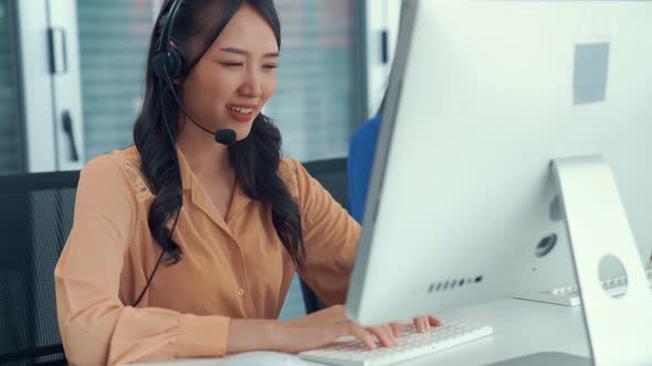 Businesswoman Wearing Headset Working Actively in Office alt