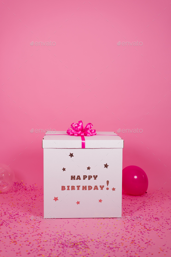 Large gift box birthday gift with pink bow with balloons next to the background Stock Photo by