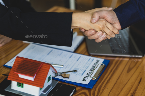 Handshake after reaching a real estate deal. Signing a house rental agreement.