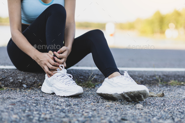 The female athlete suffered an ankle injury. A female runner has pain in her ankle.