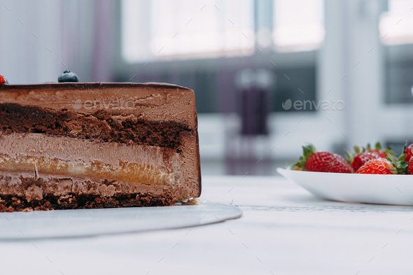 A piece of chocolate cake in the cut. Preparation of mousse cake at a culinary master class.