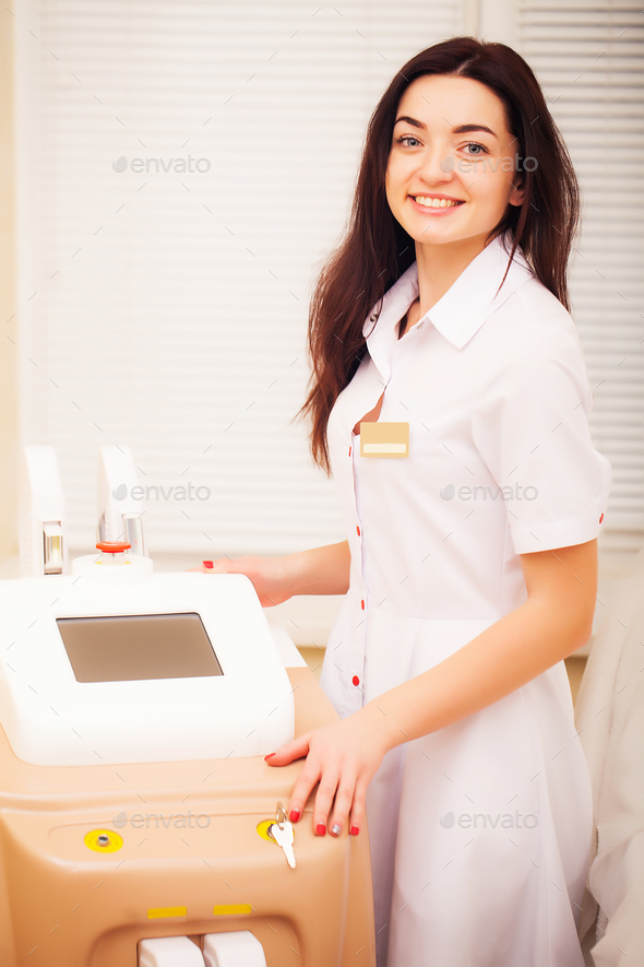 Woman doctor displaying machine for laser hair removal