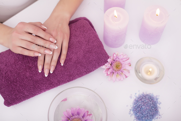 Woman hands in a nail salon receiving a hand scrub peeling by a beautician