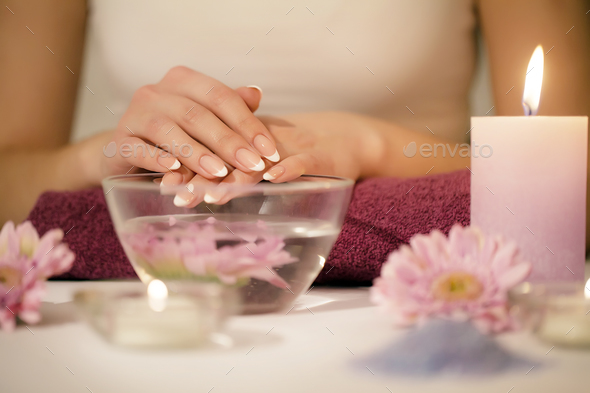 Woman hands in a nail salon receiving a hand scrub peeling by a beautician