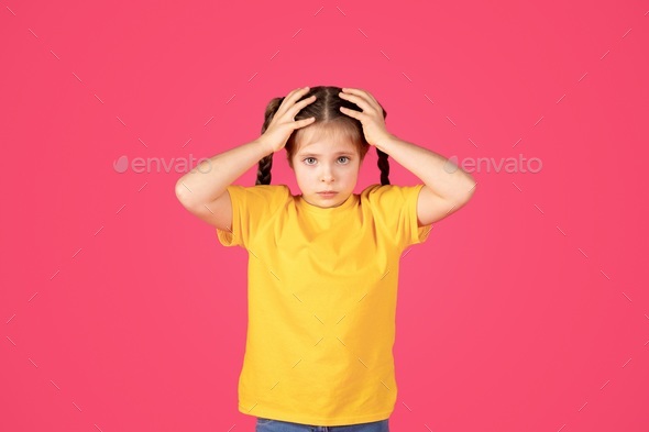 Oh No. Cute little girl having troubles, touching her head with shock ...