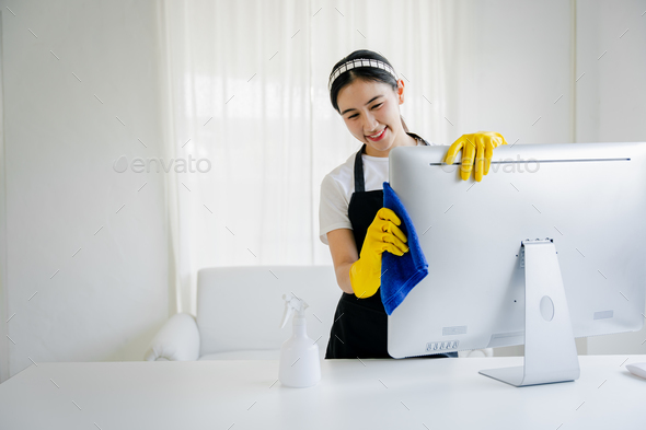 Young woman using a computer cleaning cloth to disinfect the officeoffice cleaning staff cleaning ma