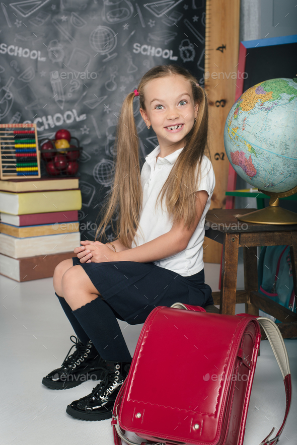 School kid with sitting in uniform. Girl is back to school