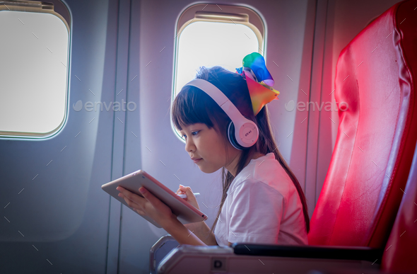 Young happiness tourist teenager passenger flight seat near window using taplet app relax litsening