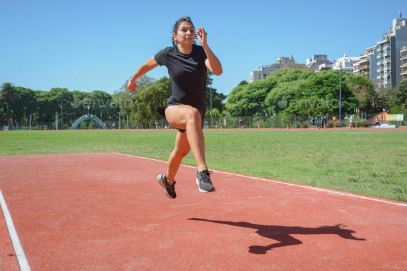 young latin woman runner training doing long jumps