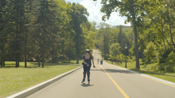 Excited Young Woman Roller Riding Up and Down Hill alt