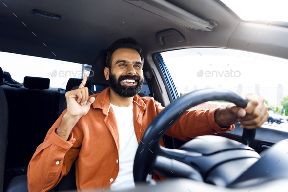 Cheerful Indian Man Riding Car And Singing Sitting Inside Vehicle