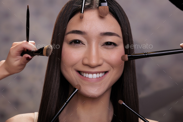 Fashion Glamour Beauty Asian Porn - Make up brushes around smiling young asian model face Stock Photo by  DC_Studio
