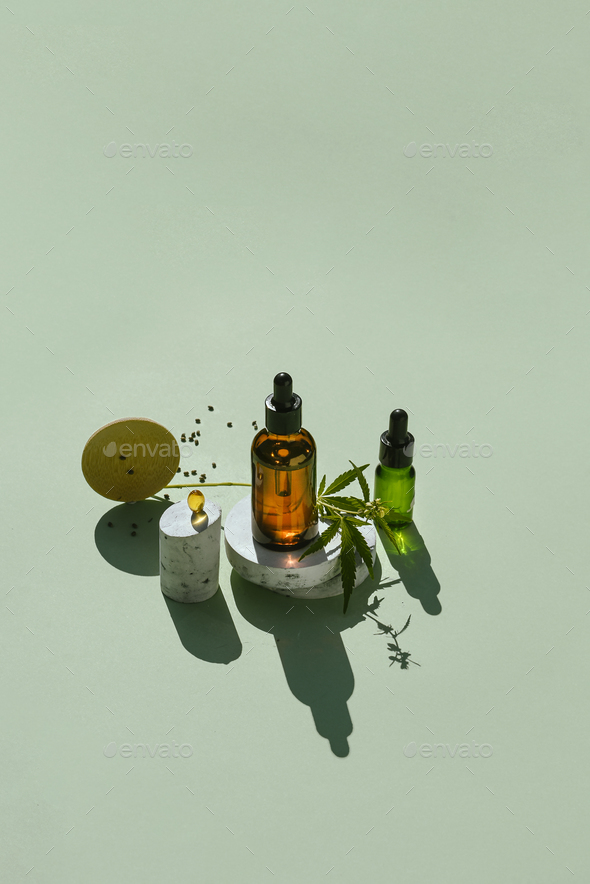 Various glass bottles with CBD oil and tincture and capsule on podiums