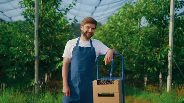 Young Farmer Showing Berry Harvest at Summer Season in Orchard Plantation House alt