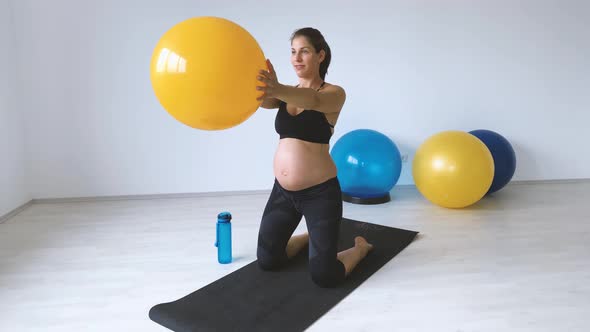 Slow motion shot of pregnant woman during exercise with exercise ball