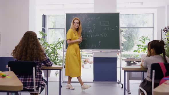 Female Teacher Explains Lesson to Children with Great Excitement and Interest alt