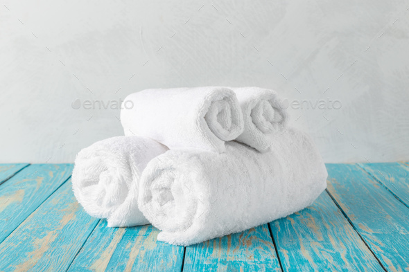 Stacked clean fluffy towels in a bathroom Stock Photo by FabrikaPhoto