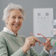 Happy senior woman trying new prescription glasses - PhotoDune Item for Sale