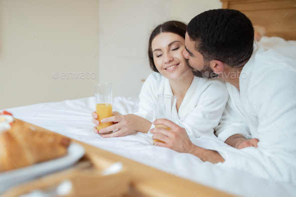 Husband Kissing Wife As Couple Enjoying Orange Juice In Hotel Stock Photo By Prostock Studio