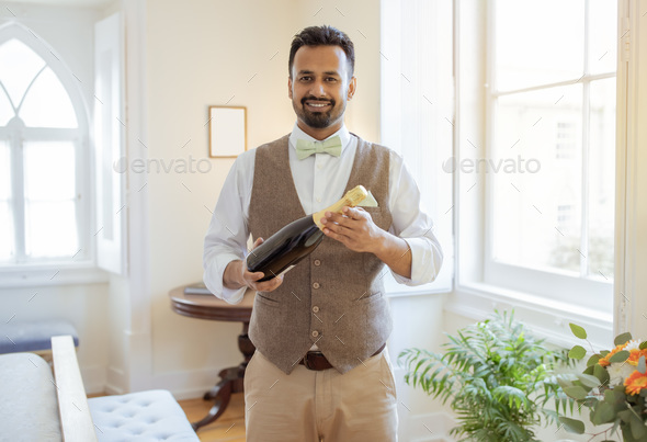 Indian Waiter Guy With Bottle Of Wine Standing At Hotel