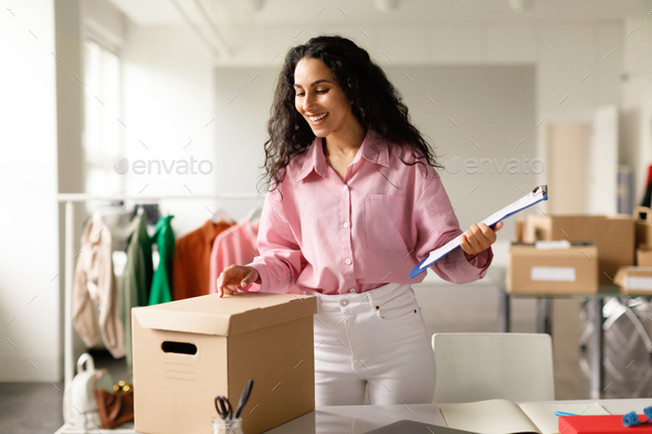 Successful Lady In Clothing Store Packing Boxes In Fashionable Showroom